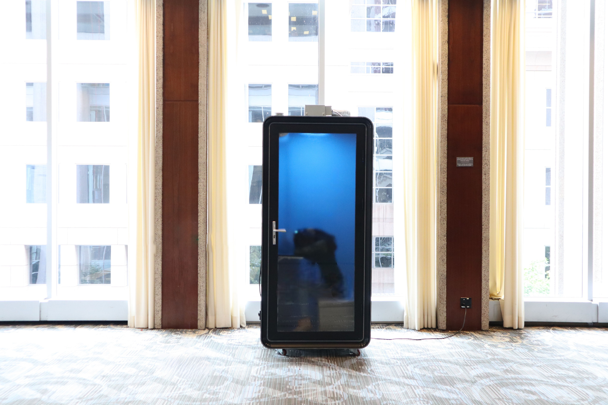 Ouvertu privacy pod with glass door in a bright open office